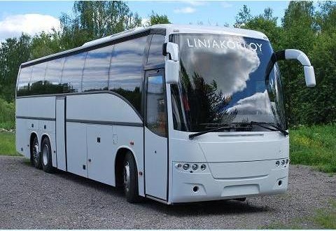 Valkoinen kolmiakselinen turistibussi, jonka tuulilasissa on Linjakori Oy:n teksti